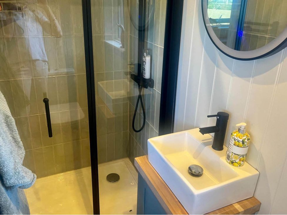 A bathroom with a shower and sink at Peaceful Shepherd Hut near Clovelly
