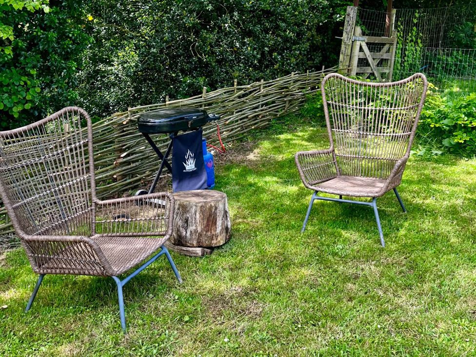 Two chairs and a grill in a garden at Peaceful Shepherd Hut near Clovelly