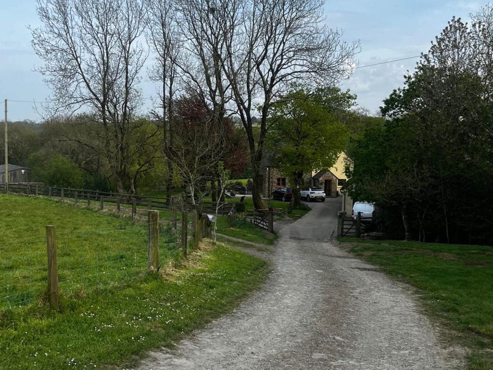 A gravel path leading to a house with trees in the surroundings at Peaceful Shepherd Hut near Clovelly Buckland Brewer near Great Torrington