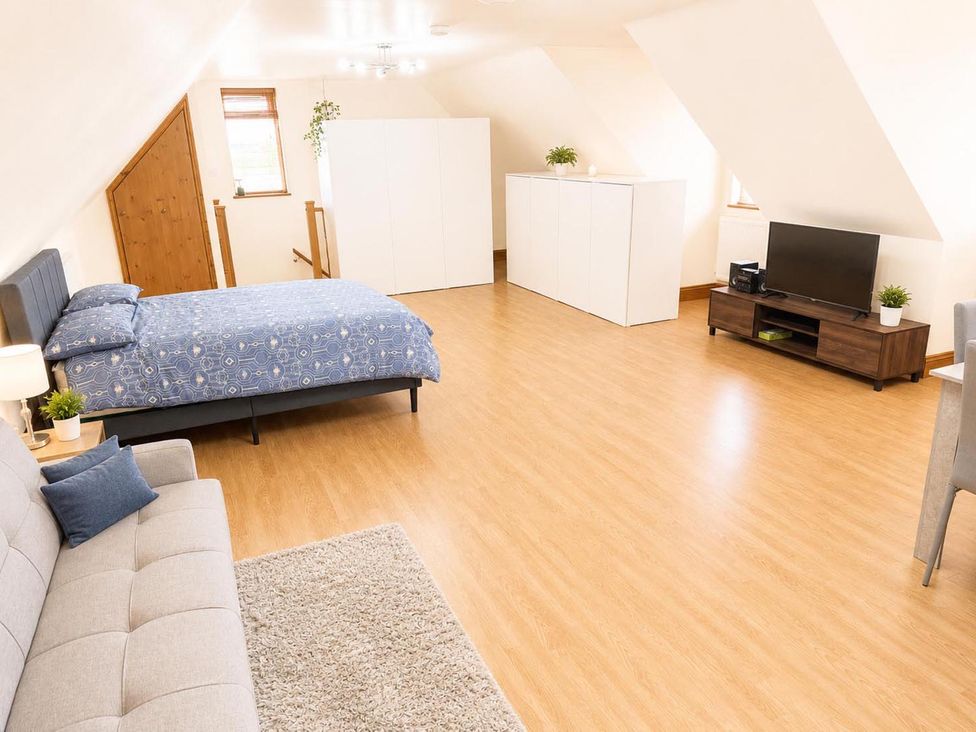 A bedroom with a bed, sofa, and television at Surridges Studio, Sleeps 4 w/ Parking & Dogs Ok, Latchingdon near Burnham-On-Crouch