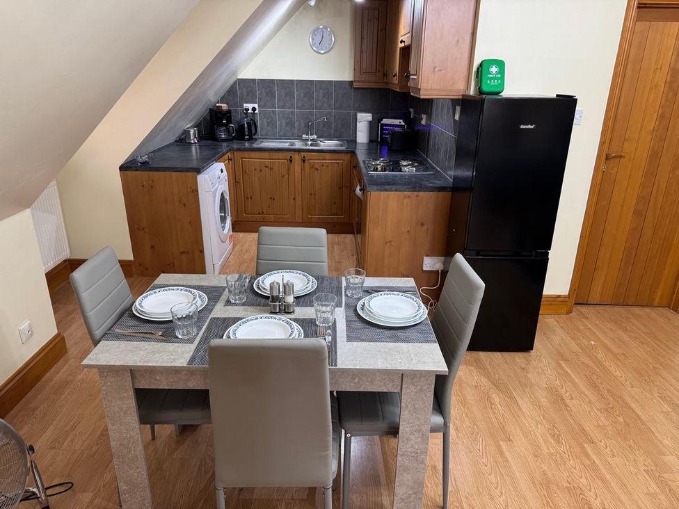 A kitchen with a dining table and appliances at Surridges Studio, Sleeps 4 w/ Parking & Dogs Ok in Latchingdon near Burnham-On-Crouch