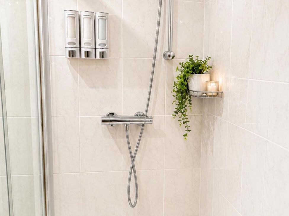 A shower area with soap dispensers and a plant holder at Surridges Studio, Sleeps 4 w/ Parking & Dogs Ok in Latchingdon near Burnham-On-Crouch