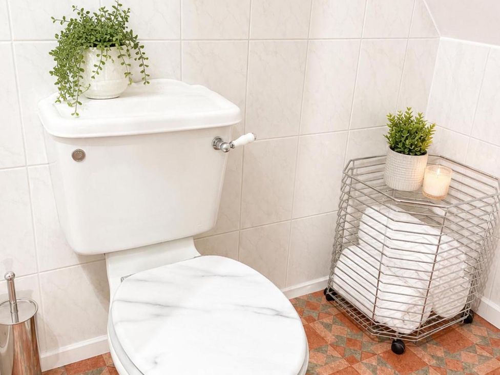 A bathroom with a toilet and storage for towels at Surridges Studio, Sleeps 4 w/ Parking & Dogs Ok, Latchingdon near Burnham-On-Crouch