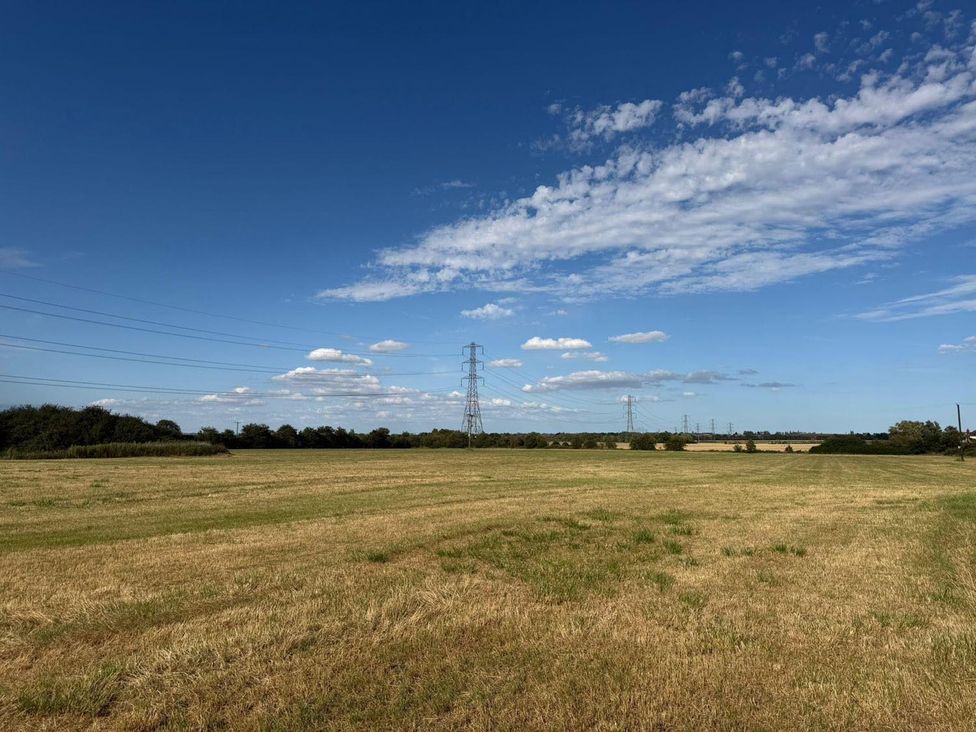 A field with power lines and trees at Surridges Studio, Sleeps 4 w/ Parking & Dogs Ok, Latchingdon near Burnham-On-Crouch