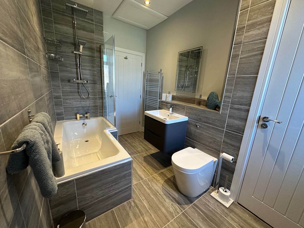 A bathroom with a bathtub, shower, sink, and toilet at Stylish Home Sleeps 4 Free Parking, Earl Shilton