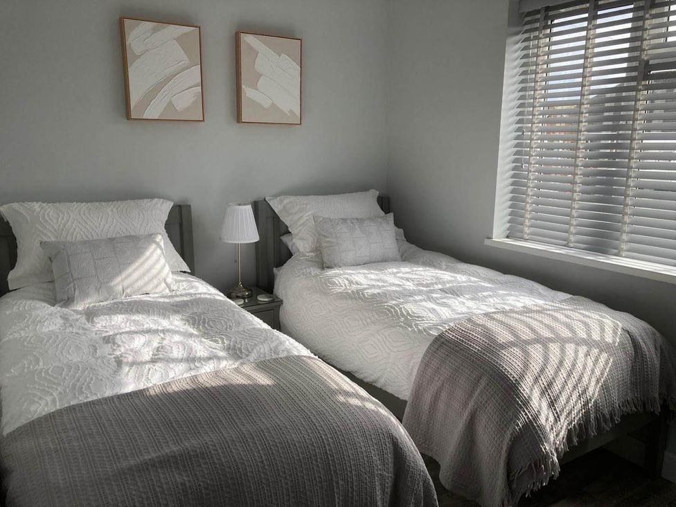A bedroom with two beds and a lamp at Stylish Home Sleeps 4 Free Parking in Earl Shilton
