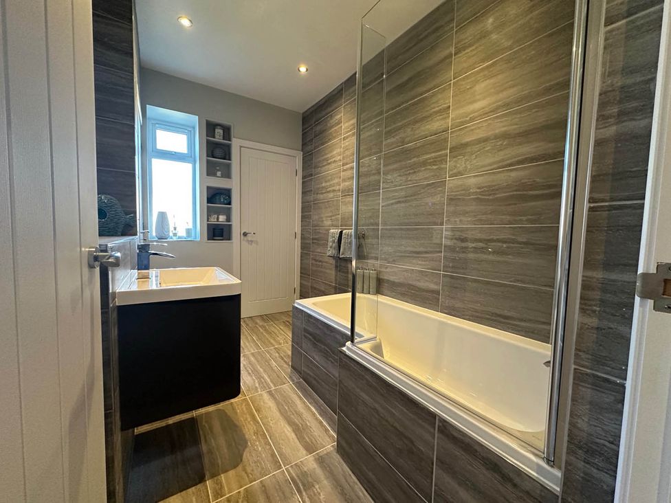 A bathroom with a bathtub and sink at Stylish Home Sleeps 4 Free Parking in Earl Shilton