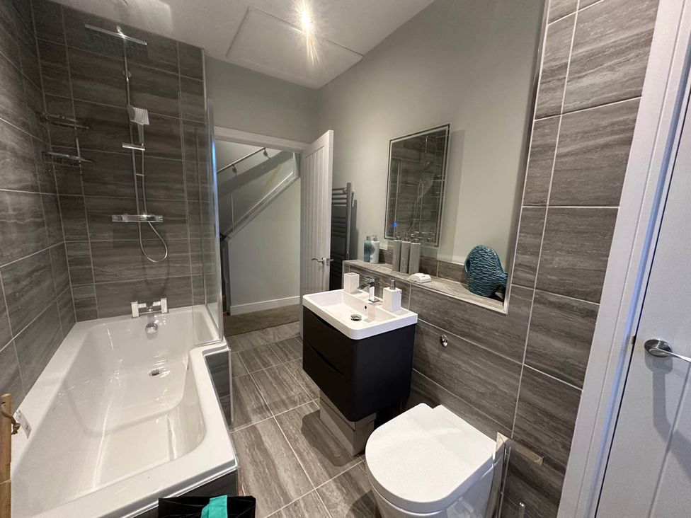 A bathroom with a bathtub, shower, toilet, and sink at Stylish Home Sleeps 4 Free Parking in Earl Shilton