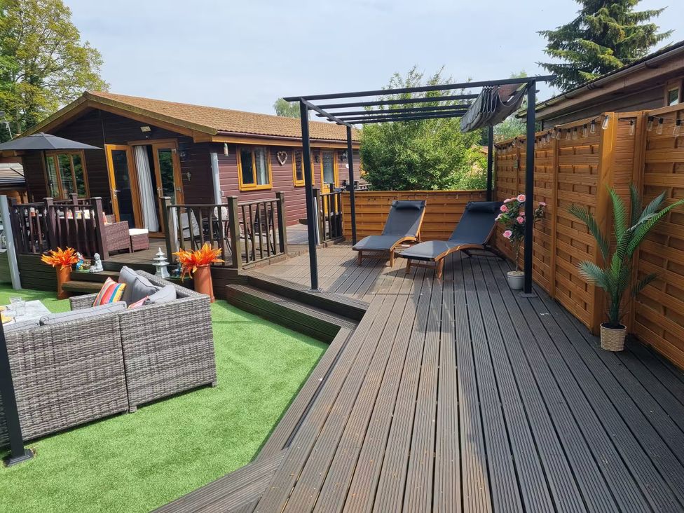 A garden with lounge chairs and outdoor seating at Cabin Sleeps 4 with Hot Tub and Parking near Wilberfoss