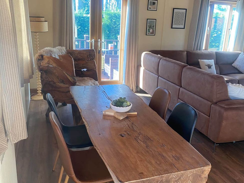 A dining area with a wooden table and chairs at Cabin Sleeps 4 with Hot Tub and Parking Near Wilberfoss