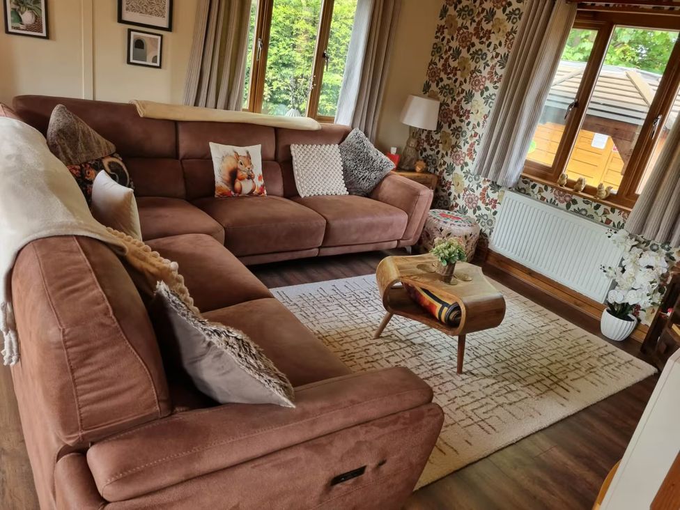 A living room with a sofa and coffee table at Cabin Sleeps 4 with Hot Tub and Parking Near Wilberfoss