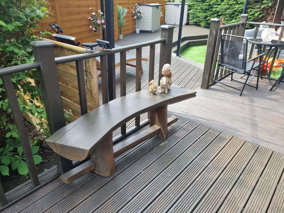 A garden with a wooden bench and figurines at Cabin Sleeps 4 with Hot Tub and Parking near Wilberfoss
