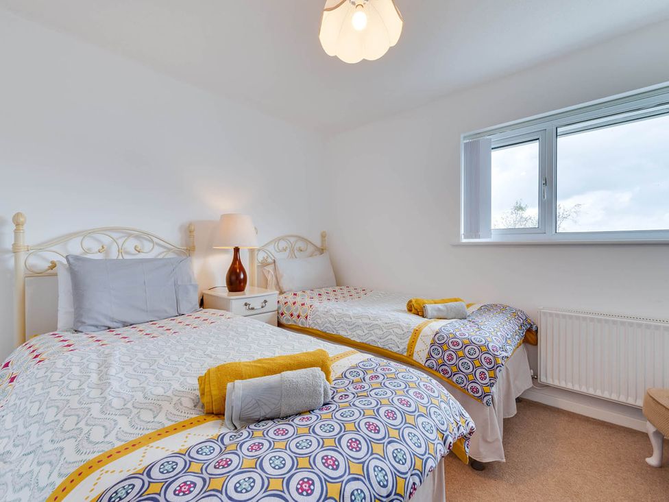 A bedroom with two beds and a window at Ty Gwyn Borth-y-gest House Sleeps 5 Garden Parking Borth-Y-Gest