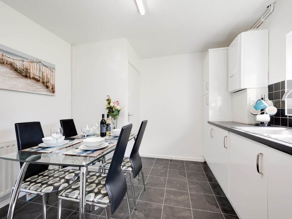 A kitchen with a dining table and chairs at Ty Gwyn Borth-y-gest House Sleeps 5 Garden Parking Borth-Y-Gest