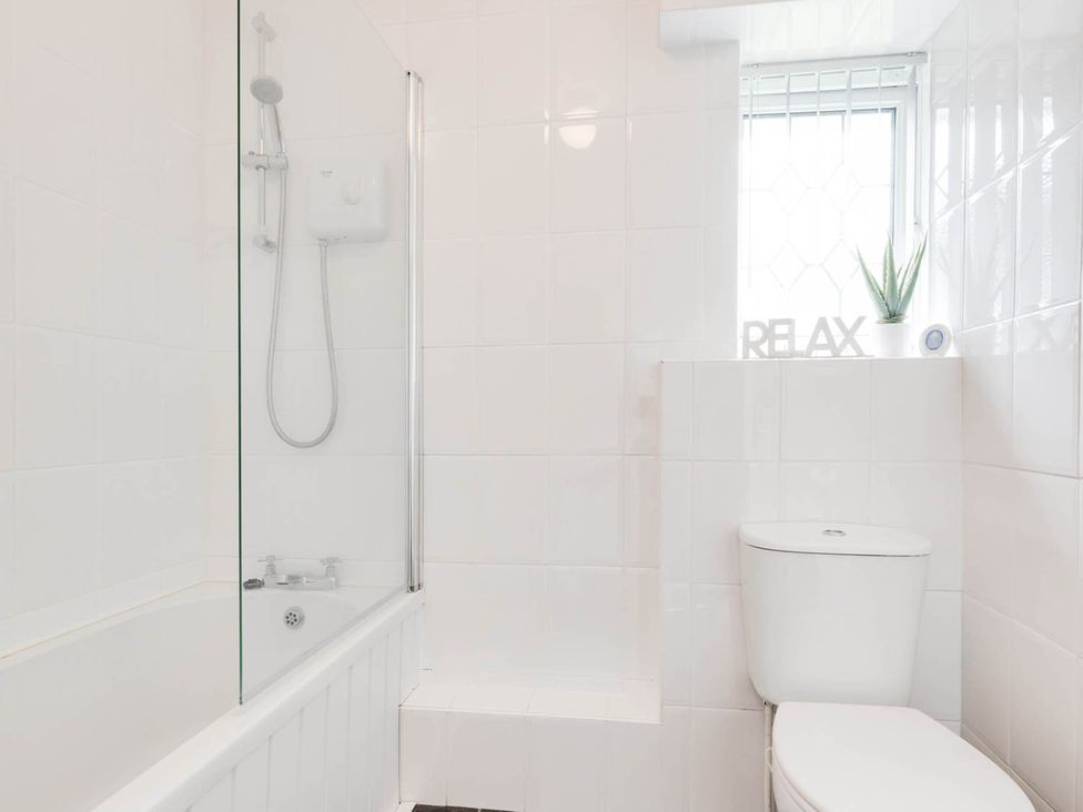 A bathroom with a bathtub and toilet at Ty Gwyn Borth-y-gest House Sleeps 5 Garden Parking Borth-Y-Gest
