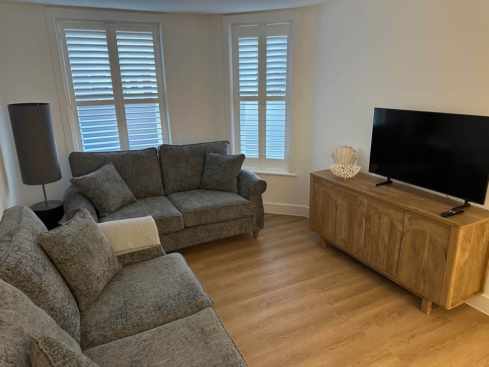 A living room with a sofa, a television, and a sideboard at 59 Whitstable - One Bedroom Ground Floor Flat in Whitstable