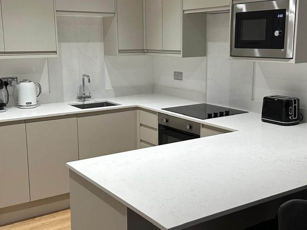 A kitchen with a sink, stove, and appliances at 59 Whitstable - One Bedroom Ground Floor Flat, Whitstable