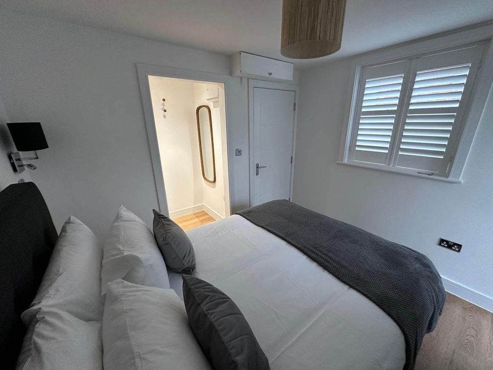 A bedroom with a bed and door to a bathroom at 59 Whitstable - One Bedroom Ground Floor Flat, Whitstable