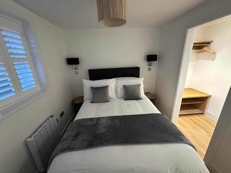 A bedroom with a bed and wardrobe at 59 Whitstable - One Bedroom Ground Floor Flat in Whitstable
