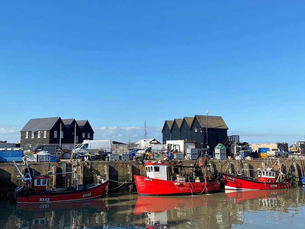 A harbor with fishing boats and storage buildings at 59 Whitstable - One Bedroom Ground Floor Flat, Whitstable