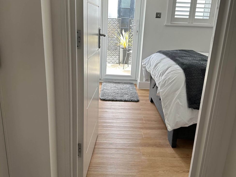 A bedroom with a bed and sliding door to an outdoor area at 59 Whitstable - One Bedroom Ground Floor Flat, Whitstable