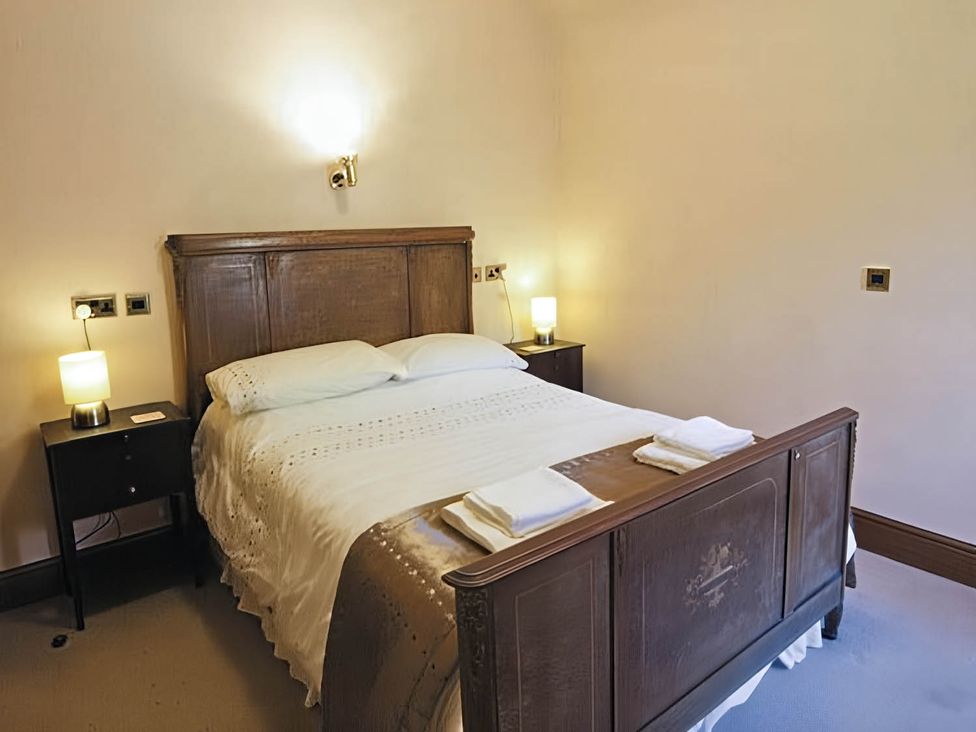 A bedroom with a bed and nightstands at The Old Barn in Barmouth