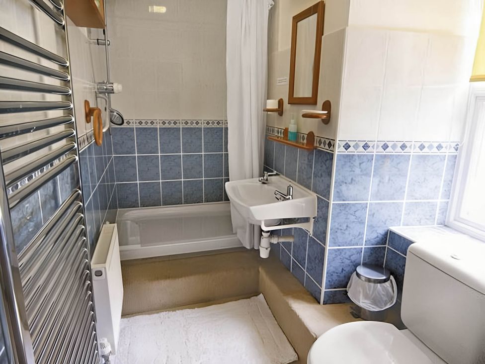 A bathroom featuring a bathtub, sink and toilet at The Old Barn in Barmouth
