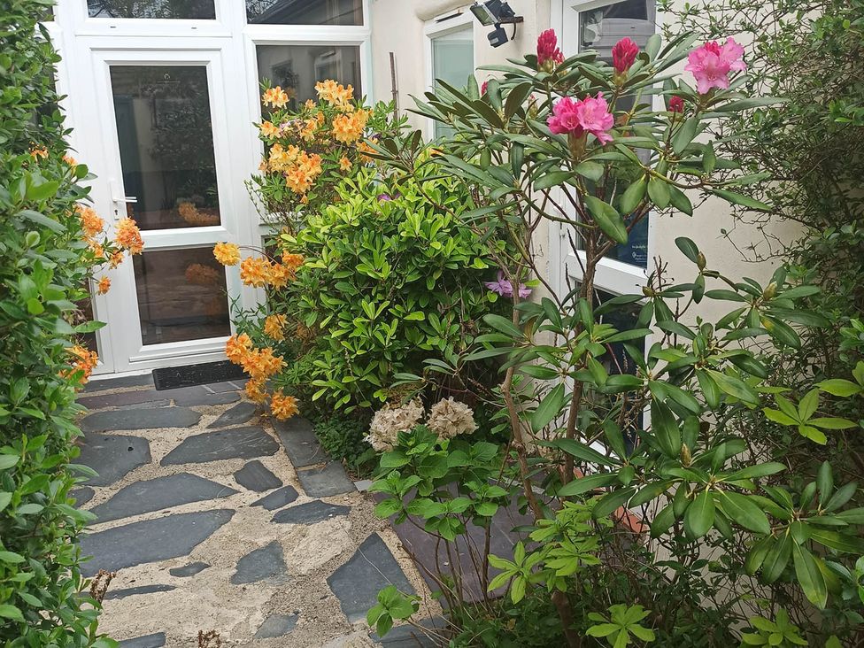 A garden with flowers and a stone path at The Old Barn in Barmouth