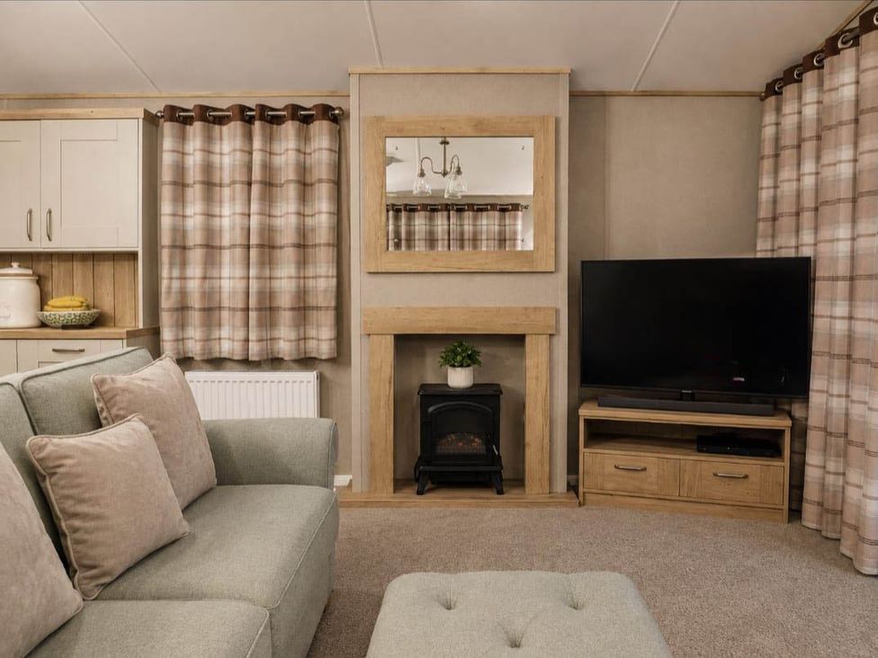 A living room with a television and sofa at Cala Gran 3Bed Caravan Sleeps 8 Wrap Decking in Fleetwood