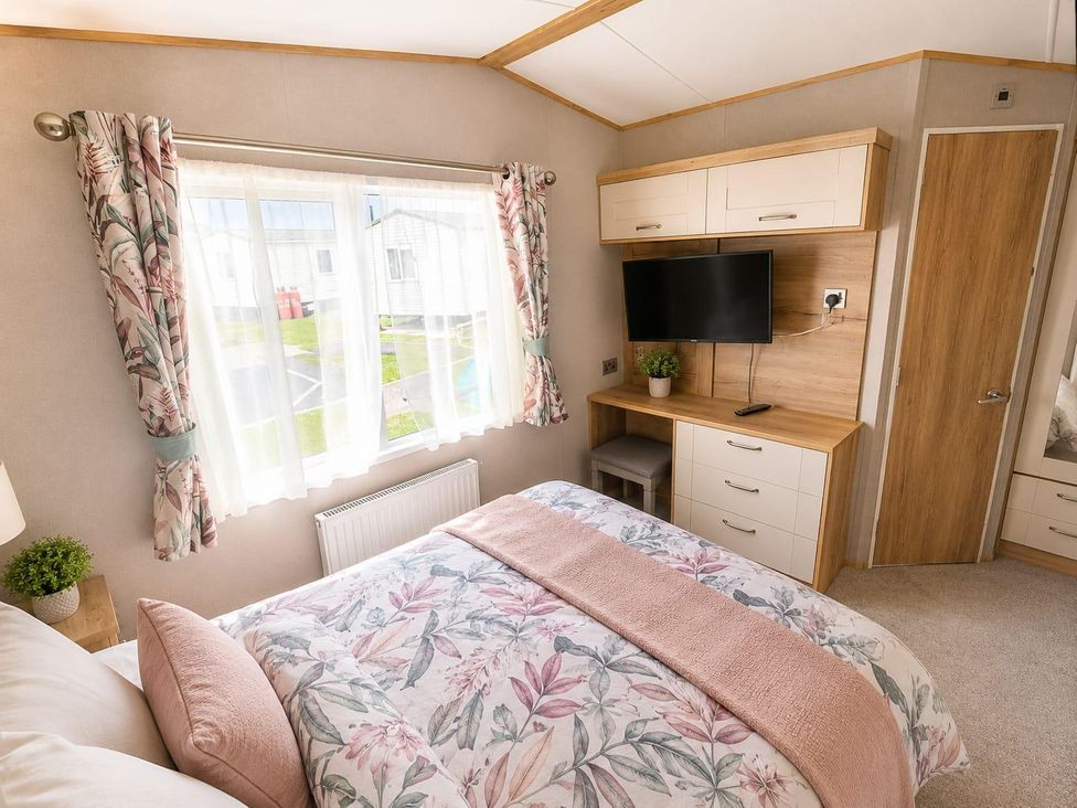 A bedroom with a bed and tv at Cala Gran 3Bed Caravan Sleeps 8 Wrap Decking in Fleetwood