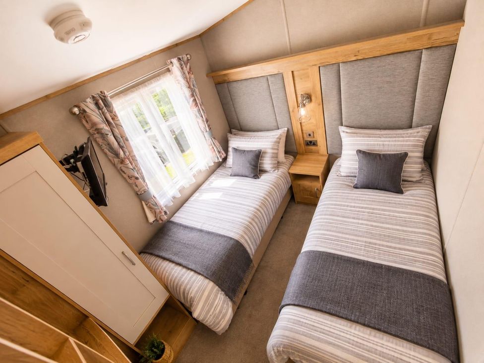 A bedroom with twin beds and a wardrobe at Cala Gran 3Bed Caravan Sleeps 8 Wrap Decking, Fleetwood