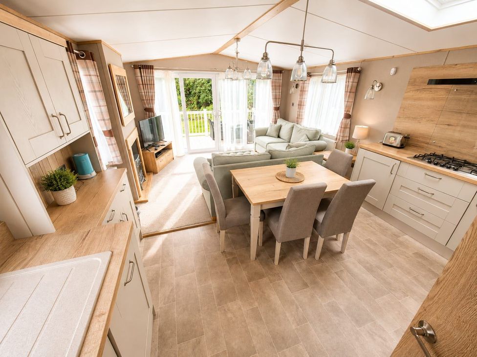 A living room with a dining table and chairs at Cala Gran 3Bed Caravan Sleeps 8 Wrap Decking Fleetwood
