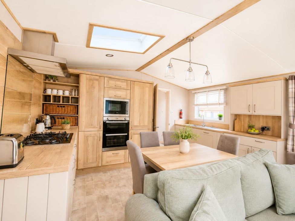 A kitchen with a table and chairs at Cala Gran 3Bed Caravan Sleeps 8 Wrap Decking in Fleetwood