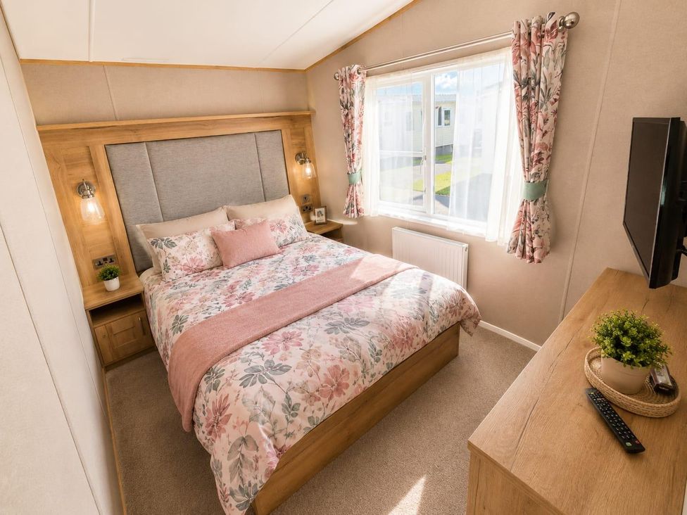A bedroom with a bed and television in Cala Gran 3Bed Caravan Sleeps 8 Wrap Decking Fleetwood