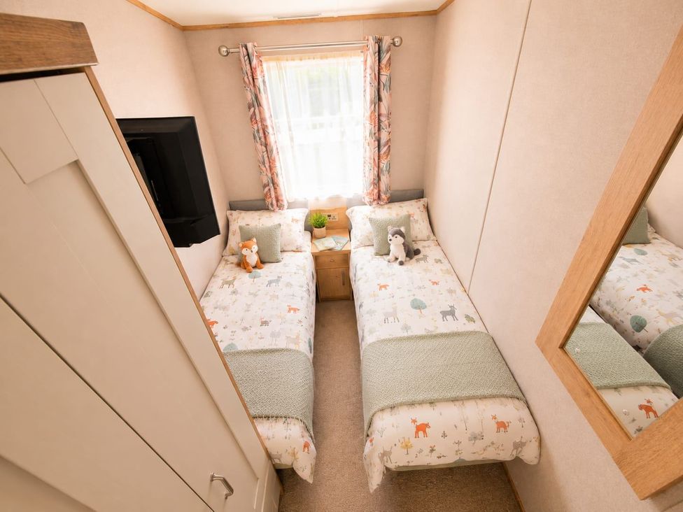 A bedroom with two beds and a wardrobe at Cala Gran 3Bed Caravan Sleeps 8 Wrap Decking Fleetwood