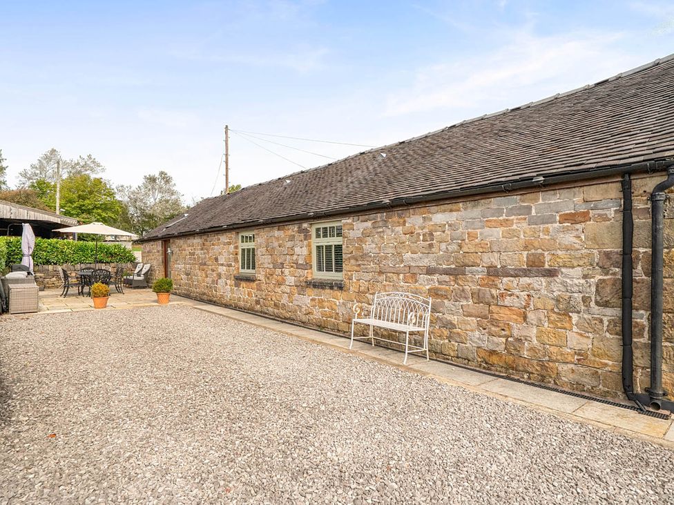 An outdoor area with a stone building and gravel surface at near Waterhouses