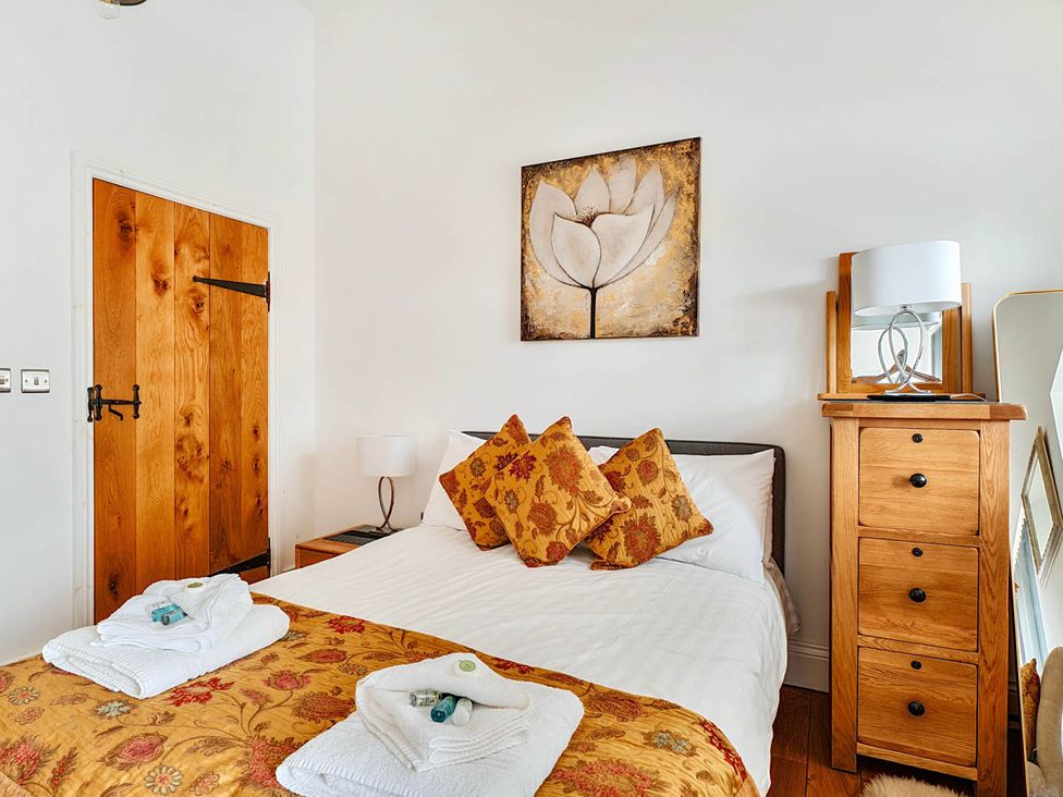 A bedroom with a bed and wooden furniture at The Old Barn Near Waterhouses