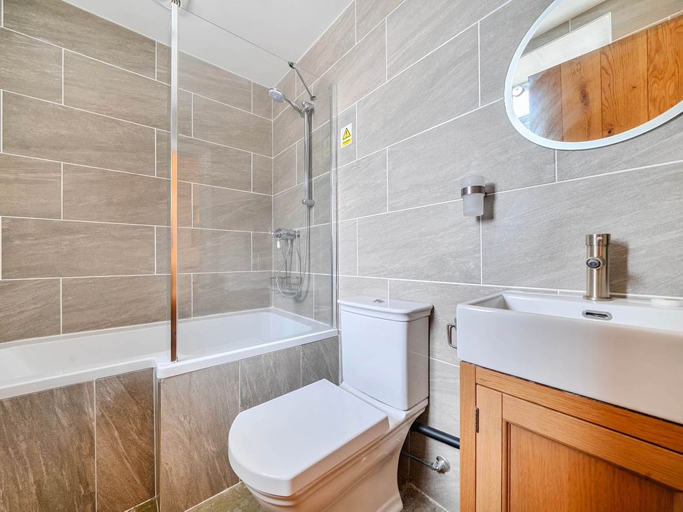 A bathroom with a bathtub, toilet, and sink at The Old Barn Near Waterhouses