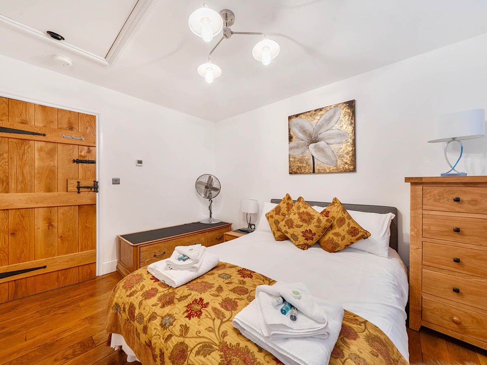 A bedroom with a bed and a wooden door at The Old Barn Near Waterhouses