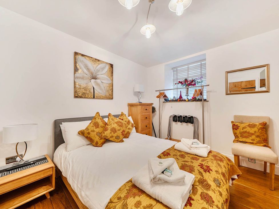 A bedroom with a bed and decorative items at The Old Barn in Near Waterhouses