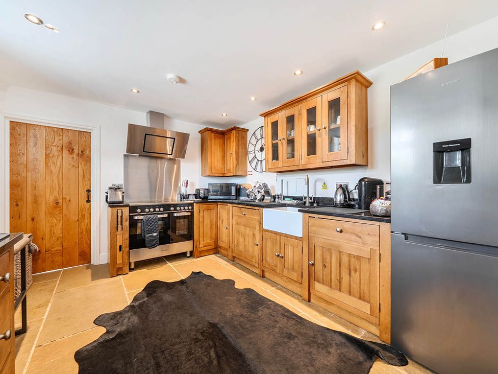 A kitchen with wooden cabinets and appliances at the property near Waterhouses