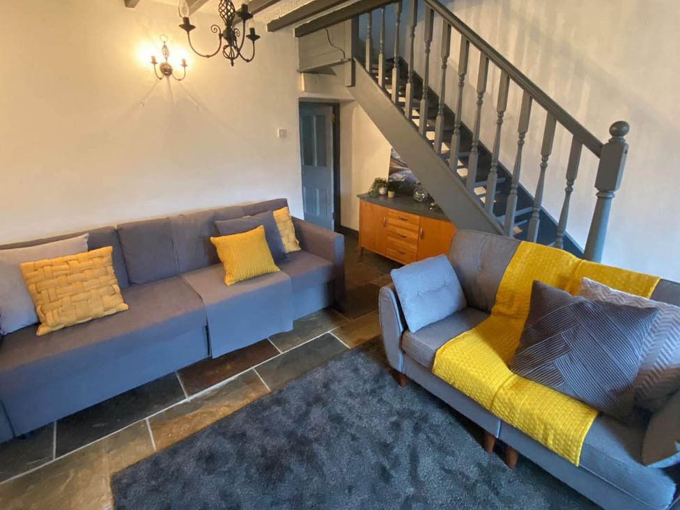 A living room with sofas and a staircase at the property in Bradworthy