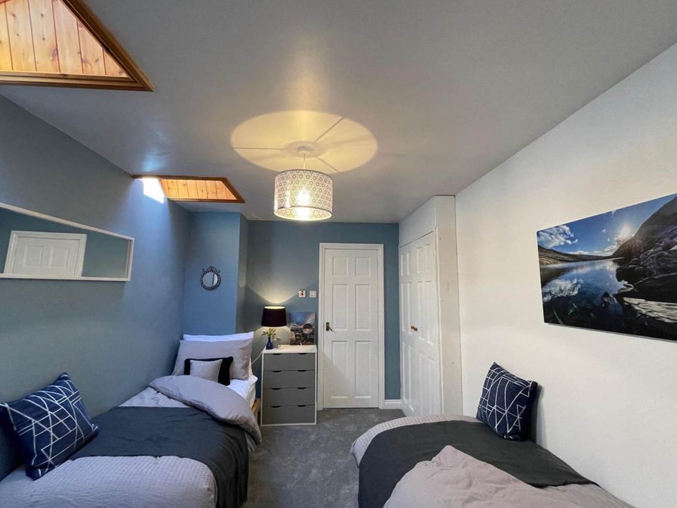 A bedroom with two beds and a chest of drawers at The Old Barn in Bradworthy