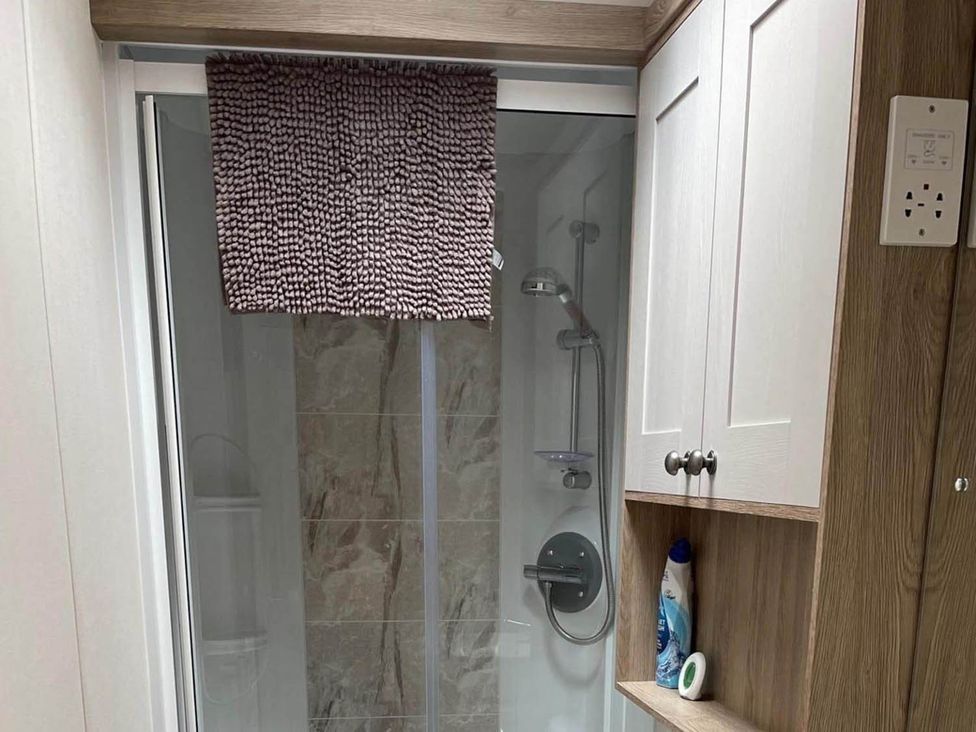 A bathroom with a shower cubicle and cabinet at The Old Barn in Manchester