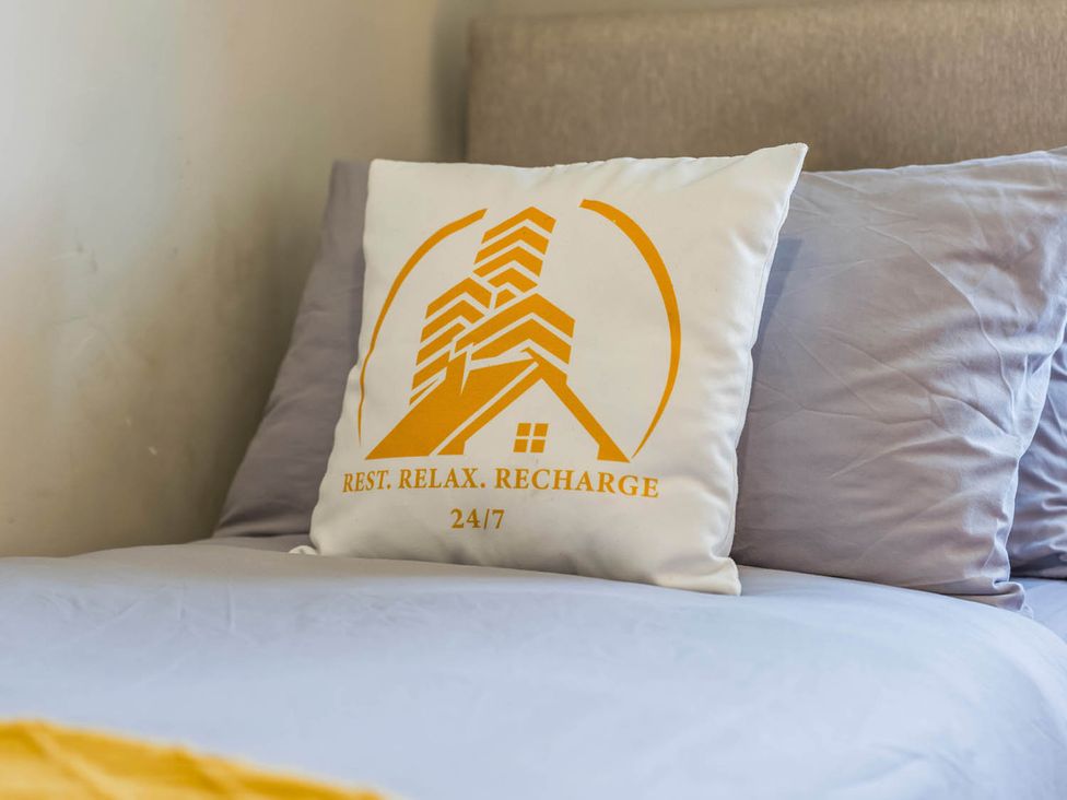A pillow on a bed with a logo at the property in Stafford