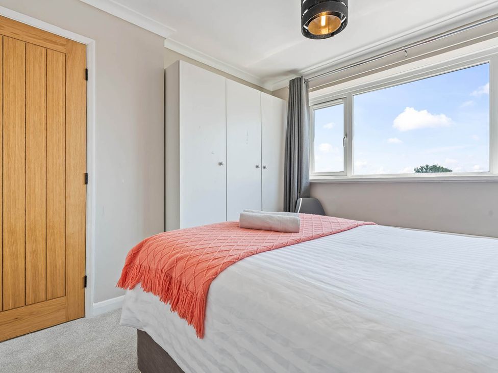 A bedroom with a bed and wardrobe at The Old Barn in Stafford