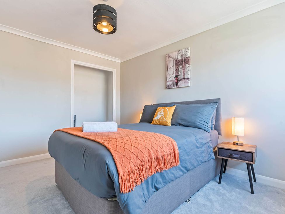 A bedroom with a bed and nightstand at The Old Barn in Stafford