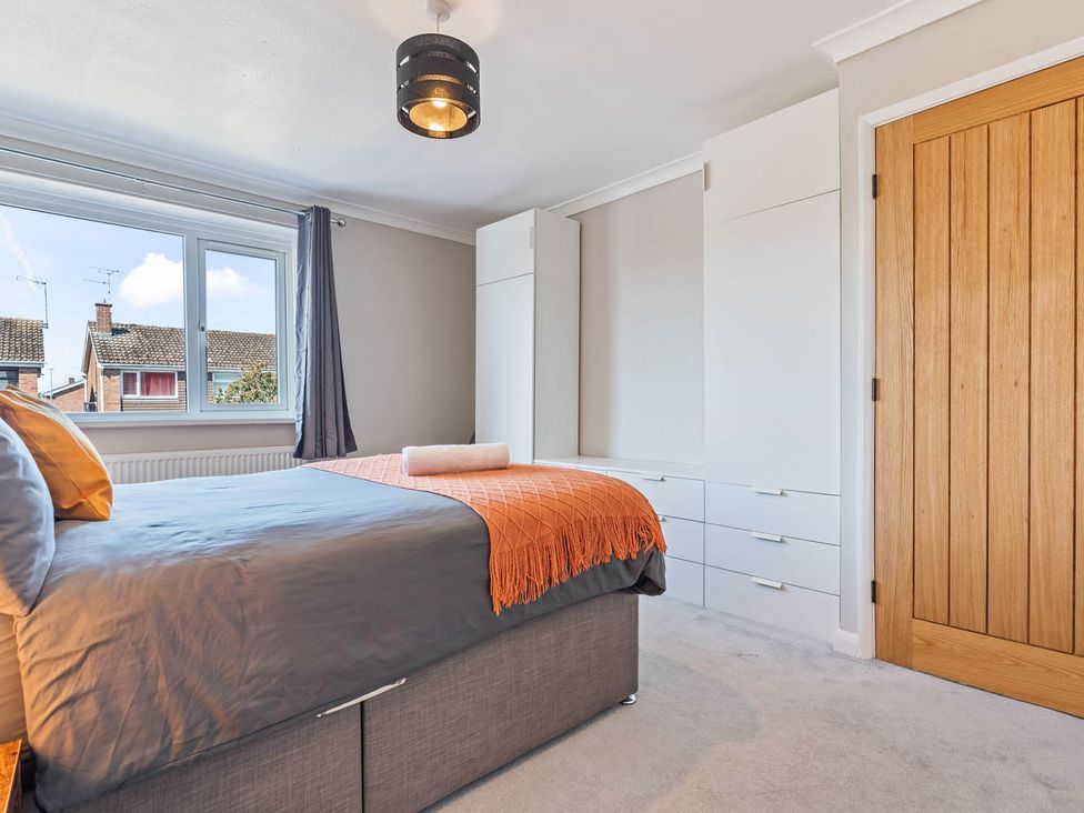 A bedroom with a bed and window at The Old Barn in Stafford