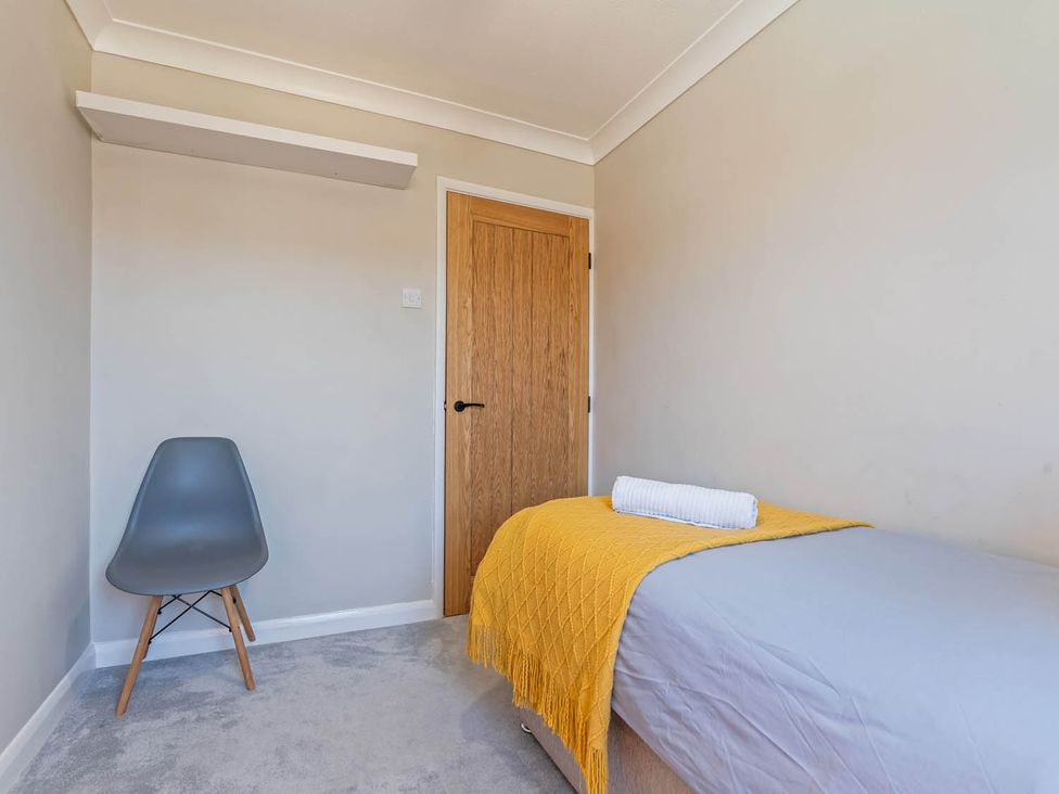 A bedroom with a bed and a chair at The Old Barn in Stafford