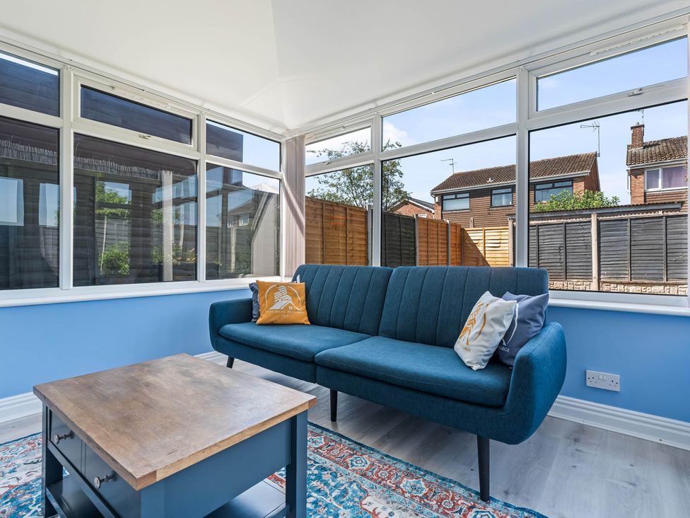 A conservatory with a sofa and coffee table at The Old Barn in Stafford